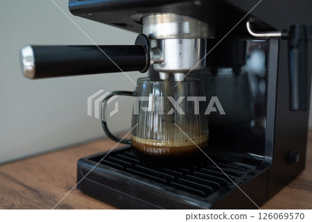 Making coffee using a modern espresso machine on a wooden table on a light background 126069570