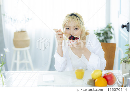 Breakfast: Woman eating yogurt 126070344