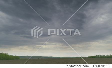 A Dramatic Cloudy Sky Over An Expansive Open Field Landscape That Captivates the Viewer 126070559