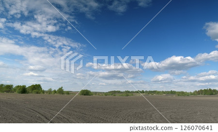 A Vast and Expansive Agricultural Landscape Sprawls Under a Bright Blue Sky Above 126070641