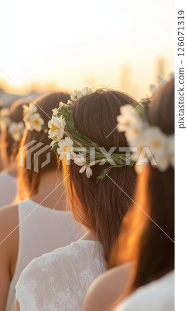 Young caucasian women with floral crowns at outdoor gathering during sunset 126071319