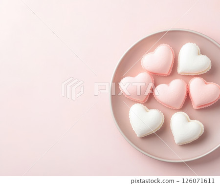 Delightful heart shaped meringues in pink and white on pastel plate, perfect for celebrations or sweet treats. Their charming design adds touch of love to any occasion 126071611