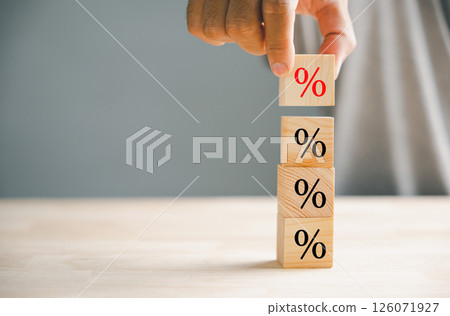 Concept of interest rate and mortgage rates. Hand positioning a wooden cube block that represents growth and an upward direction, accompanied by a percentage symbol. Concept of interest rate and mortgage rates. Hand positioning a wooden cube block that represents growth and an upward direction, accompanied by a percentage symbol. 126071927