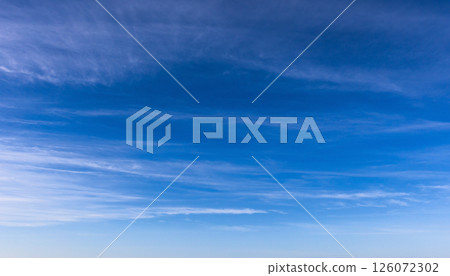 An expansive view of a clear blue sky, featuring thin, wispy cloud 126072302
