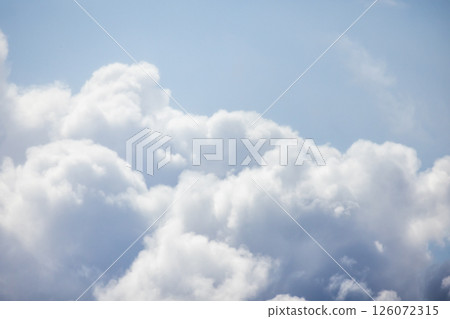 Soft, fluffy white clouds float in a serene bright blue sky Soft, fluffy white clouds float in a serene bright blue sky 126072315