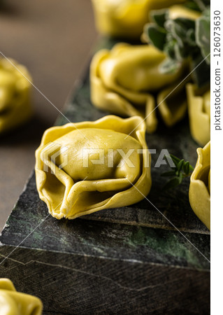 Fresh Tortellini with Herbs on Dark Green Background Fresh Tortellini with Herbs on Dark Green Background 126073630