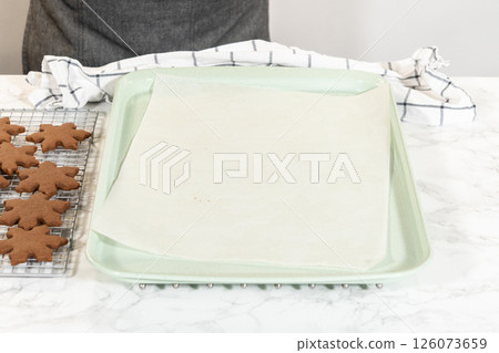 A clean parchment-lined baking tray set on a marble surface, ready for Chocolate Ginger Sugar Cookies. Front-facing perspective. A clean parchment-lined baking tray set on a marble surface, ready for Chocolate Ginger Sugar Cookies. Front-facing perspective. 126073659