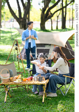 Mother and daughter enjoying a relaxing breakfast at a campsite Mother and daughter enjoying a relaxing breakfast at a campsite 126074377