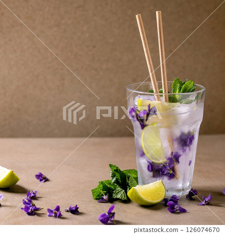 Glass of lemonade cocktail with violets flowers Glass of lemonade cocktail with violets flowers 126074670
