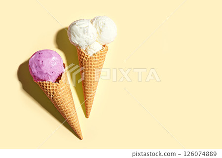 Two ice cream cones vanilla and blueberry flavors 126074889
