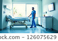 nurse pushing hospital bed through bright room, healthcare setting with view on greenery outside, medical facility 126075629