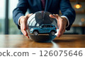 hands holding crystal ball with a car inside, concept of automotive protection and insurance 126075646