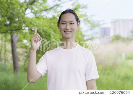 Portrait of a young man standing in a park Portrait of a young man standing in a park 126076094