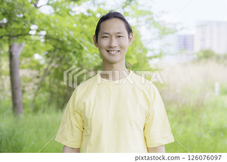 Portrait of a young man standing in a park 126076097