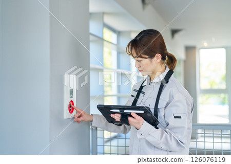 一名婦女檢查緊急警報設備 一名婦女檢查緊急警報設備 126076119