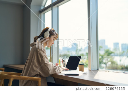 A woman working wearing headphones A woman working wearing headphones 126076135