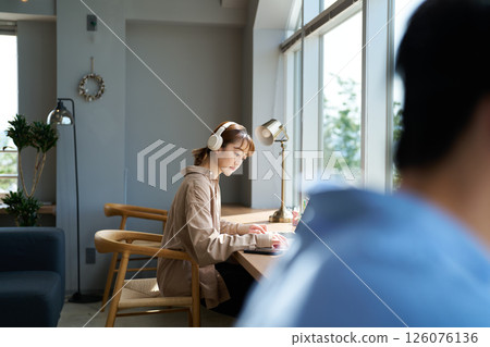 A woman working wearing headphones 126076136