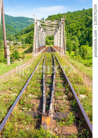 old railroad passes through the valley. transportation background. mountainous countryside in morning light. sunny weather with blue sky and clouds. travel season old railroad passes through the valley. transportation background. mountainous countryside in morning light. sunny weather with blue sky and clouds. travel season 126076209