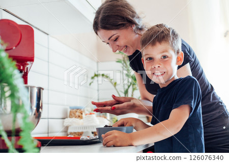 Woman with son preparing food in the kitchen dessert Woman with son preparing food in the kitchen dessert 126076340