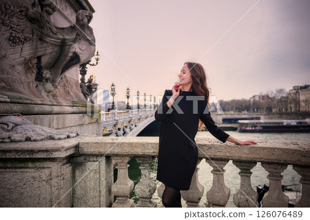 Elegant woman posing on Parisian bridge with river view.05.04.2025 Paris France Elegant woman posing on Parisian bridge with river view.05.04.2025 Paris France 126076489