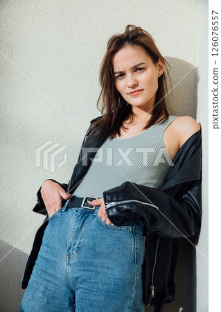 brunette woman posing in jeans and black leather jacket brunette woman posing in jeans and black leather jacket 126076557