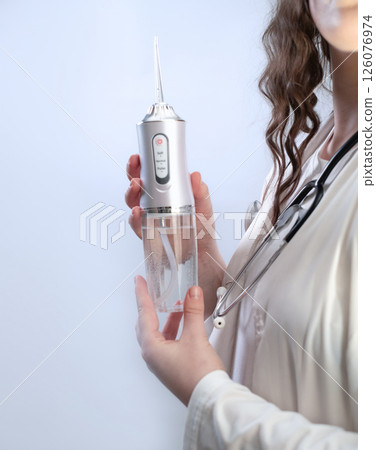 Oral care under dentist's guidance: water flosser as a key tool in preventing cavities and gum inflammation. Oral care under dentist's guidance: water flosser as a key tool in preventing cavities and gum inflammation. 126076974