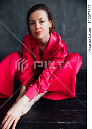 40 year old woman in pajamas sitting on the floor 40 year old woman in pajamas sitting on the floor 126077295