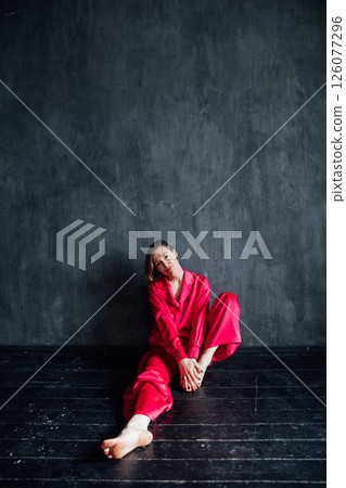 40 year old woman in pajamas sitting on the floor 40 year old woman in pajamas sitting on the floor 126077296