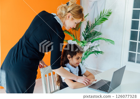 Schoolgirl Doing Homework At Table With Laptop Schoolgirl Doing Homework At Table With Laptop 126077328