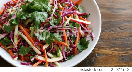 Fresh vegetable and apple salad with cilantro on a wooden table 126077530