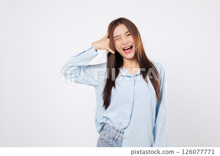 Call me gesture from cheerful woman, second woman winking uses hand as phone with fingers by face, both showing fun and flirty expressions isolated in white studio background setting. Call me gesture from cheerful woman, second woman winking uses hand as phone with fingers by face, both showing fun and flirty expressions isolated in white studio background setting. 126077771