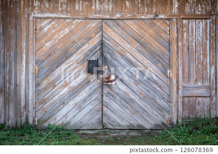 Old Wooden Barn Door with Rustic Lock and Weathered Wood Panels Old Wooden Barn Door with Rustic Lock and Weathered Wood Panels 126078369