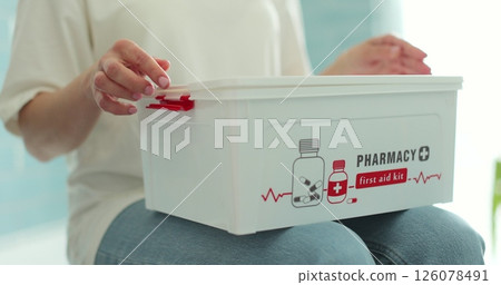 Woman takes out blister of pills from first aid kit at home. Woman takes out blister of pills from first aid kit at home. 126078491