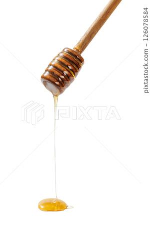 wooden honey dipper with golden honey dripping 126078584