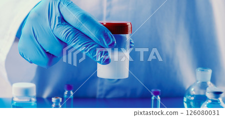 lab worker holds a container with semen, banner 126080031