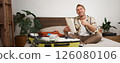 Cheerful young man, tourist with check list, showing his notes in notebook, thumbs up, packing suitcase, going on holiday, travelling abroad and preparing luggage 126080106