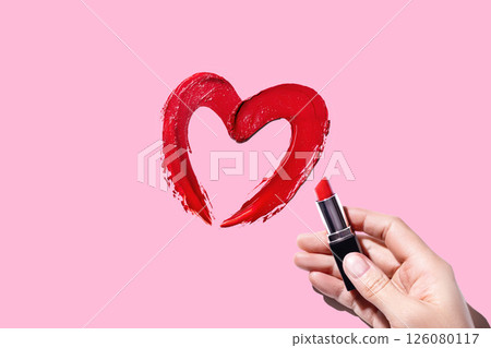 Hand draws a heart with red lipstick on pink background Cosmetic product swatch 126080117