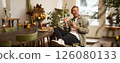 Happy young man in coffee shop, drinking cappuccino, listening to funny podcast in earphones, holding smartphone. Handsome male cafe visitor, turns on favourite song on mobile phone music app 126080133