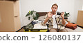 Portrait of young handsome man, travel photographer, shows okay sign, sits with camera on bed, packing things in suitcase, going on holiday or vacation abroad 126080137