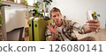 Excited young man shows his suitcase, takes selfie with okay sign on mobile phone, poses with luggage, goes on holiday 126080141