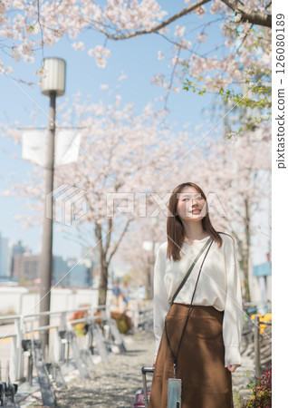 Woman traveling during cherry blossom season Woman traveling during cherry blossom season 126080189