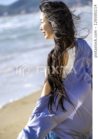 A young woman walking on the beach (Miyajihama Beach, Fukuoka Prefecture) 126080214