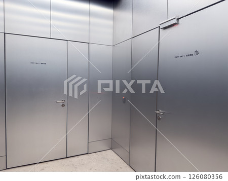 Closed metallic staff doors with service elevator sign and card reader. Restricted access area in modern public space. Concept of workplace safety and authorized personnel only 126080356