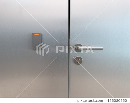 Closed metal office door with smart card reader and secure handle. Symbol of corporate access control, staff only zones, modern building security and workplace infrastructure 126080360