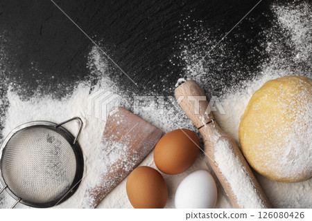 Baking utensils and dough laying on flour flat lay view with copyspace Baking utensils and dough laying on flour flat lay view with copyspace 126080426