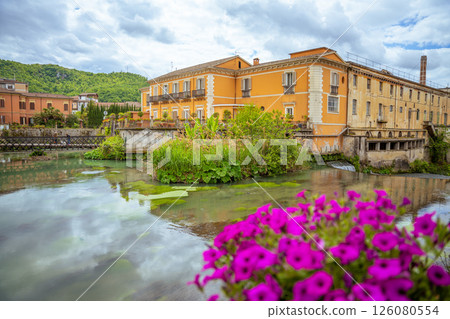 Isola del Liri's picturesque riverfront with historic buildings and vibrant flowers.. 126080554
