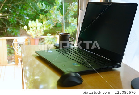 Trees in the garden seen from the window, a computer used for remote work 126080676