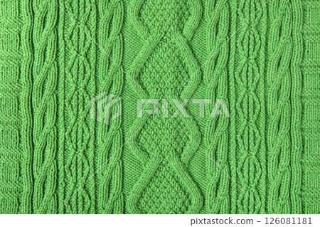 Knitted green background. Large knitted fabric with a pattern. Close-up of a knitted blanket Knitted green background. Large knitted fabric with a pattern. Close-up of a knitted blanket 126081181