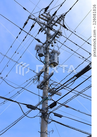 A utility pole with many crossing wires 126081816