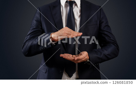 Businessman gesturing to place text or products against black background 126081850